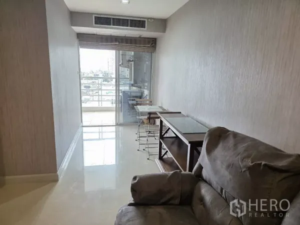 公寓 出租在Khlong Toei, Bangkok - 狭长客厅通向玻璃推拉门与带城市景观的阳台。