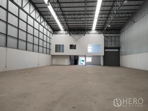 Factory for rent in Phra Nakhon Si Ayutthaya - Spacious warehouse hall with 9m high steel roof, mezzanine offices and a large roller shutter door.