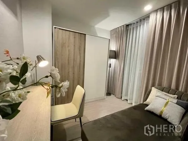 Condominium for rent in Chatuchak, Bangkok - Secondary bedroom or study featuring a desk, chair, wardrobe and full-height curtains.