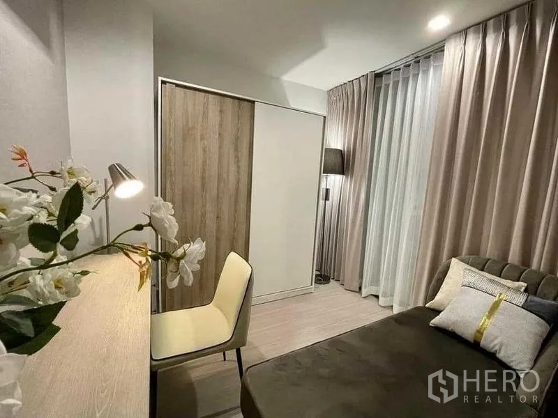 Condominium for rent in Chatuchak, Bangkok - Secondary bedroom or study featuring a desk, chair, wardrobe and full-height curtains.