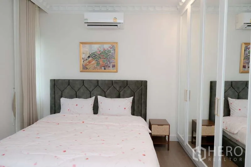 Detached House for rent or sale in Saphan Sung, Bangkok - Guest bedroom with mirrored closets and wall-mounted air conditioner.