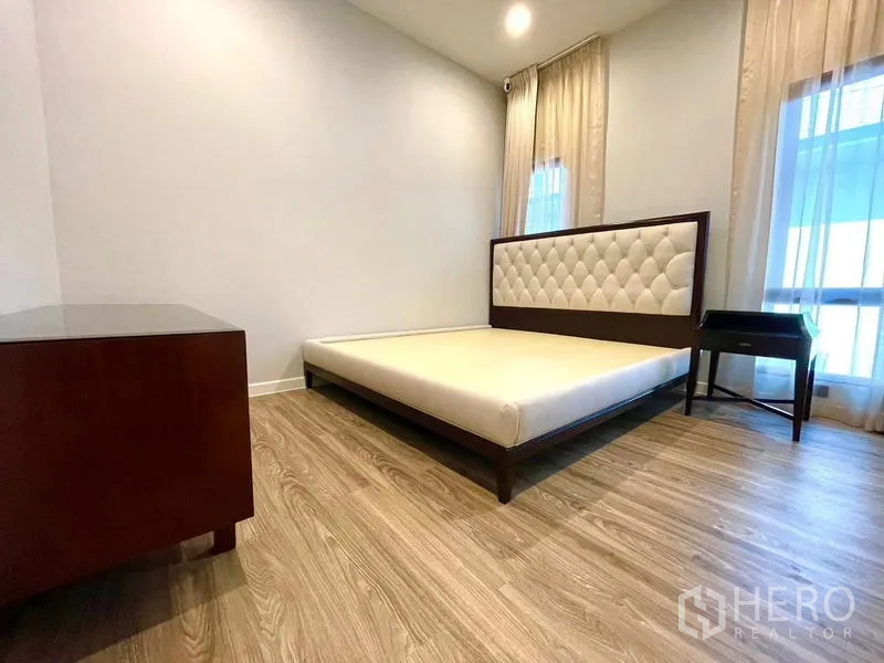 Detached House for rent in Bang Kapi, Bangkok - Corner bedroom with wood flooring, wide windows and bedside tables.