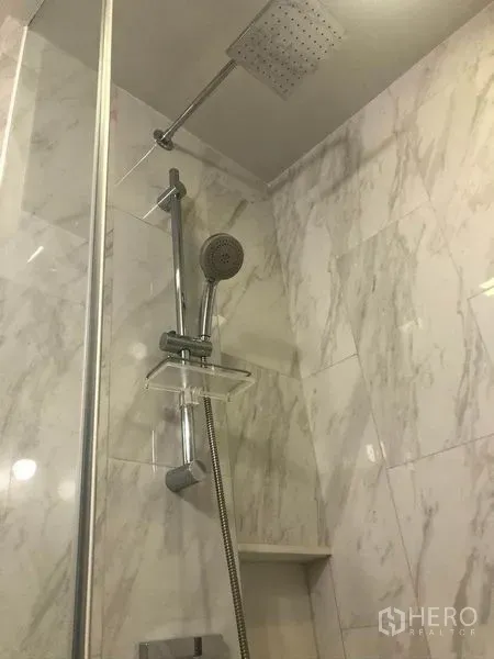 公寓 出售在Watthana, Bangkok - 大理石墙面的浴室，配顶喷与手持花洒。
