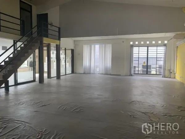 Retail Space for rent in Khlong Toei, Bangkok - Spacious open-plan retail interior with high ceiling, mezzanine staircase, glass partitions and large windows.