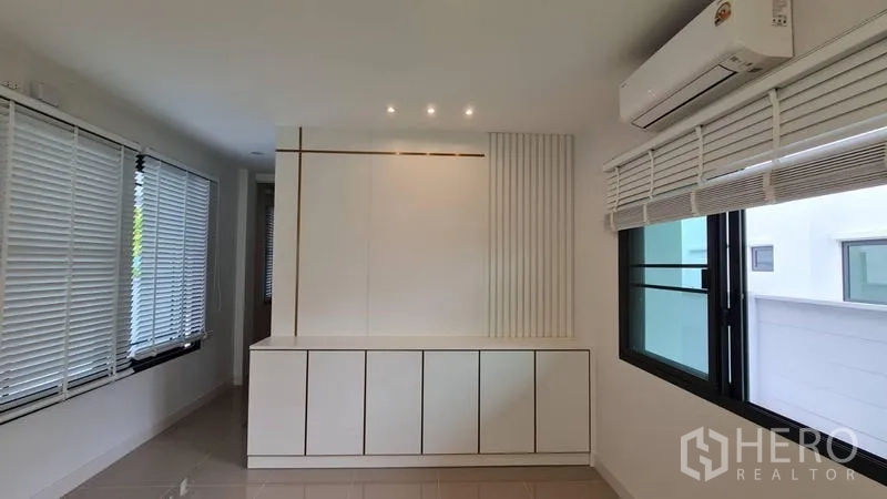 Detached House for rent in Samut Prakan - Bright multi-purpose room with built-in storage cabinetry and windows on two sides.