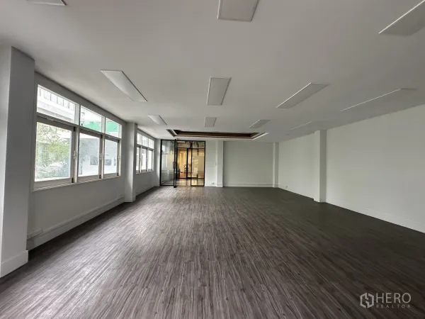 Retail Space for rent in Bang Rak, Bangkok - Long open space with rows of windows and glass entry doors.