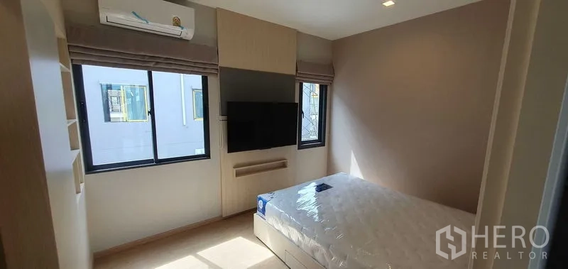 带办公室的家 出租在Prawet, Bangkok - 采光良好的卧室，双人床、壁挂电视与转角窗。