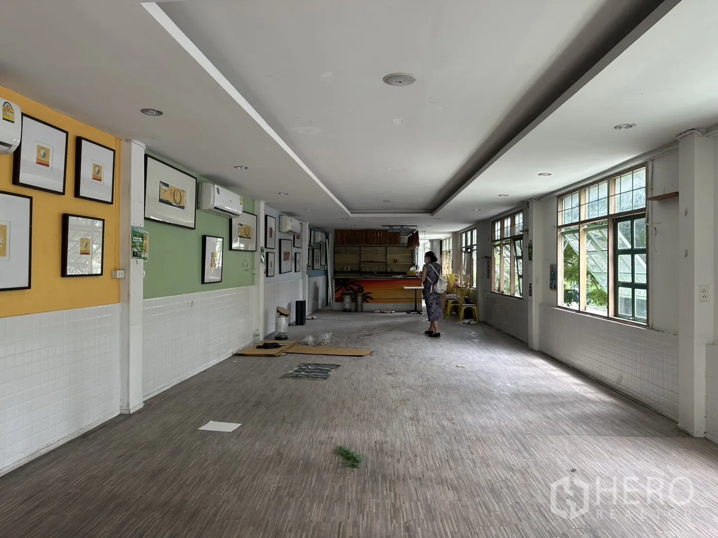 零售空间 for rent in Sathon, Bangkok - 画框装饰的画廊式墙面，多台空调，明亮通厅通向服务吧台。