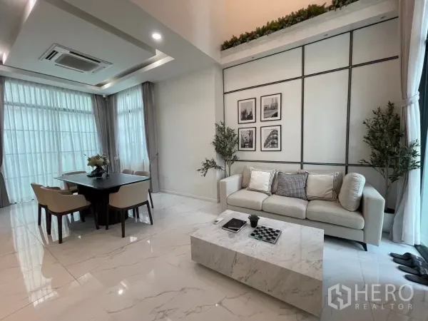 独立式住宅 出租在Lat Phrao, Bangkok - 采光充足的客餐厅，仿大理石地面，沙发与餐桌临落地窗