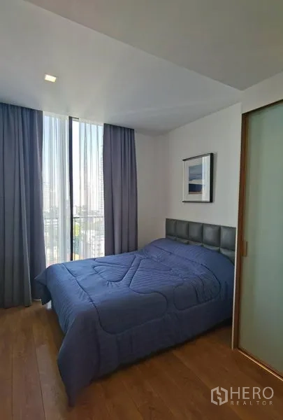 公寓 出租在Watthana, Bangkok - 温馨卧室，双人床与软包床头，大窗与遮光窗帘，可观城市景色。