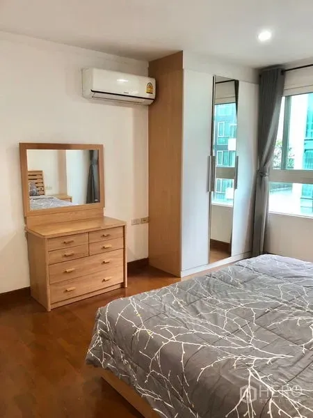 公寓 出租或出售在Watthana, Bangkok - 卧室一角，带梳妆台、镜面衣柜、窗户与空调
