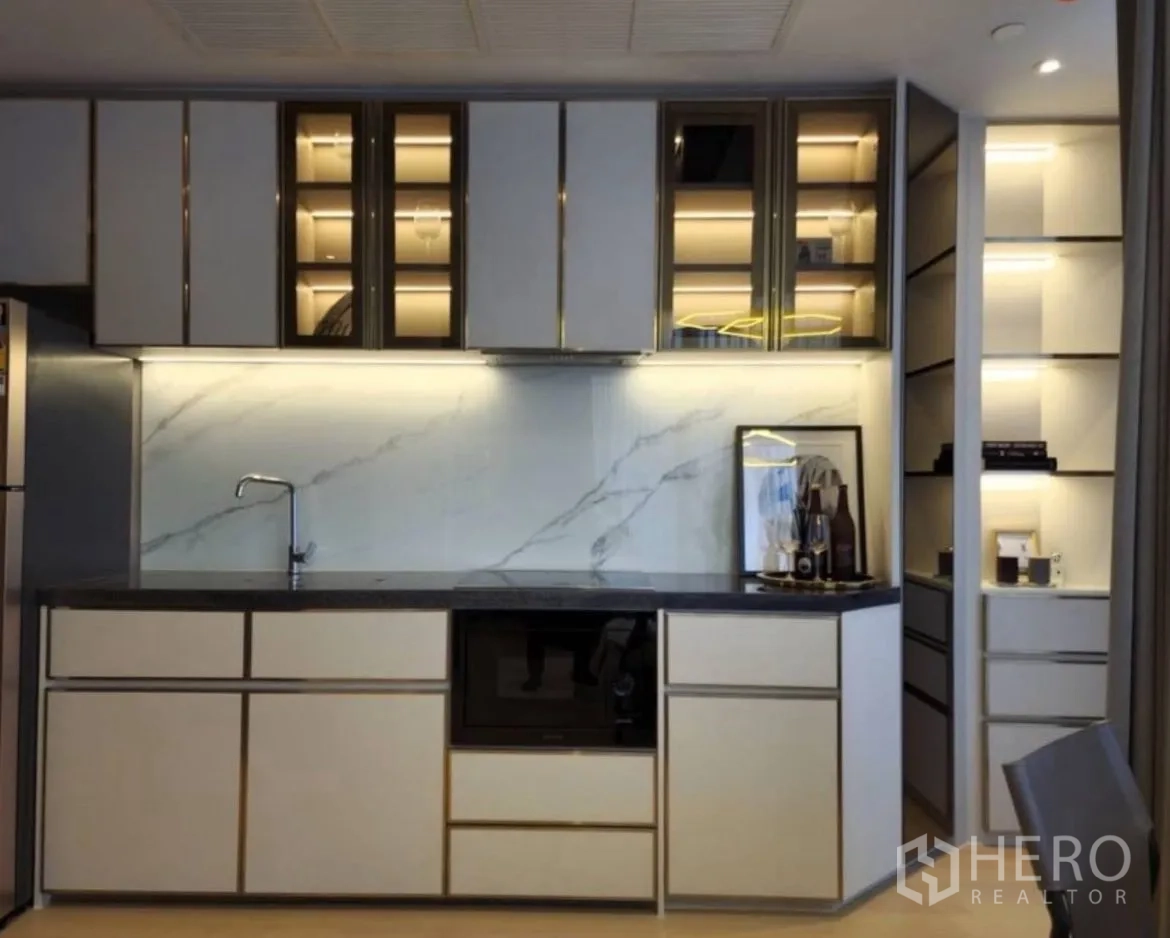 Condominium for rent in Din Daeng, Bangkok - Close-up of sleek kitchen cabinets with marble backsplash and under-cabinet lighting.