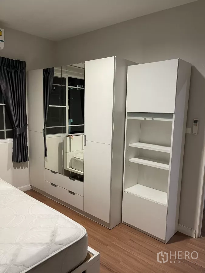 Detached House for rent in Bang Kapi, Bangkok - Bedroom with white bed frame, air conditioner and corner windows.