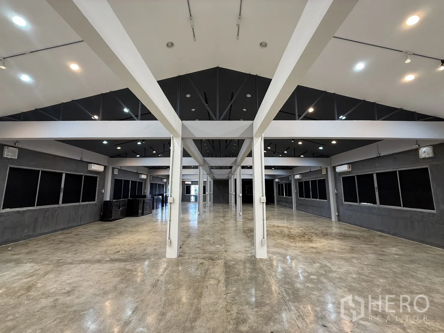 办公空间 出租在Wang Thonglang, Bangkok - 对称视角的长厅，立柱、抛光地面与窗户。