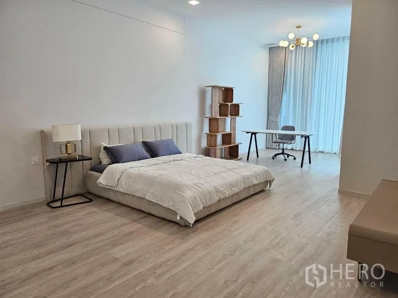 Detached House for rent - Spacious bedroom with light wood flooring, king bed, work desk and floor‑to‑ceiling curtains.