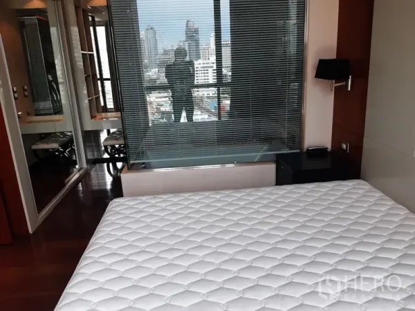 Condominium for rent in Khlong Toei, Bangkok - Bedroom with glass partition to ensuite bathroom and built-in storage.