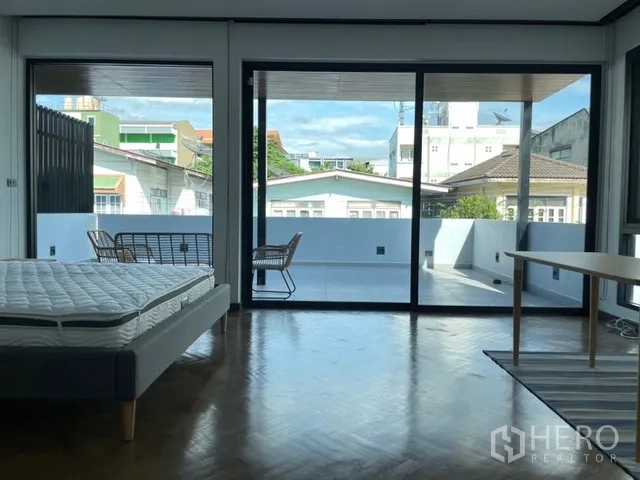 独栋房屋 for rent in Watthana, Bangkok - 卧室面向宽阳台的大幅推拉门景。