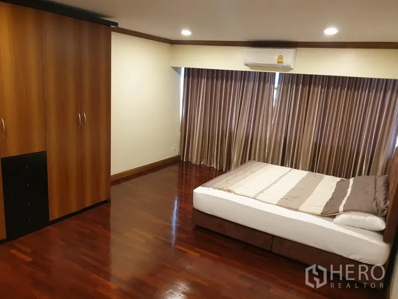 公寓 出租在Watthana, Bangkok - 卧室配大窗与落地窗帘，分体空调与衣柜，地板为实木。