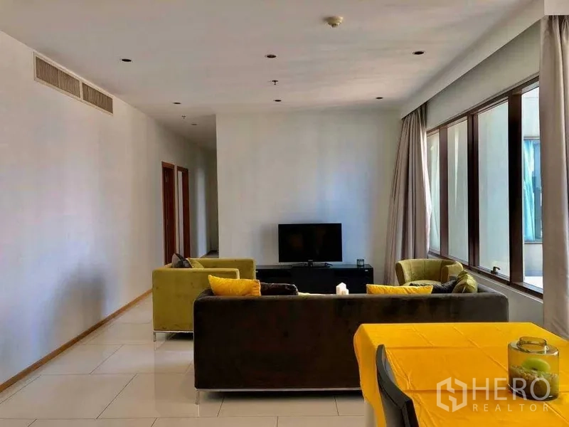 公寓 出售在Khlong Toei, Bangkok - 从餐区望向客厅，转角窗、沙发组与电视柜