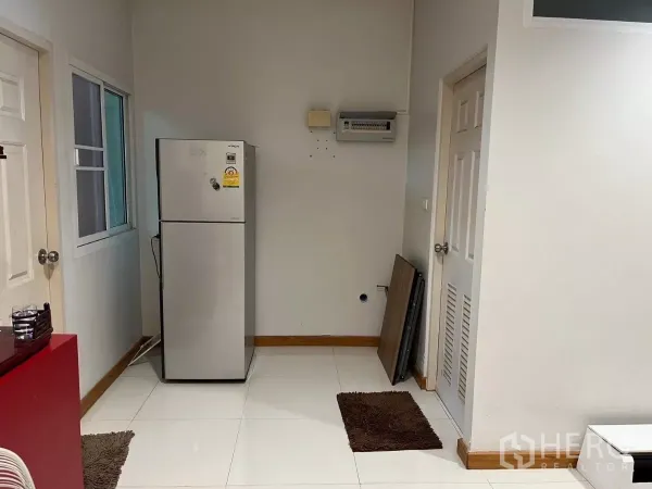 Townhouse for rent in Bang Kho Laem, Bangkok - Utility and pantry corner with refrigerator, interior doors, and tiled floor.