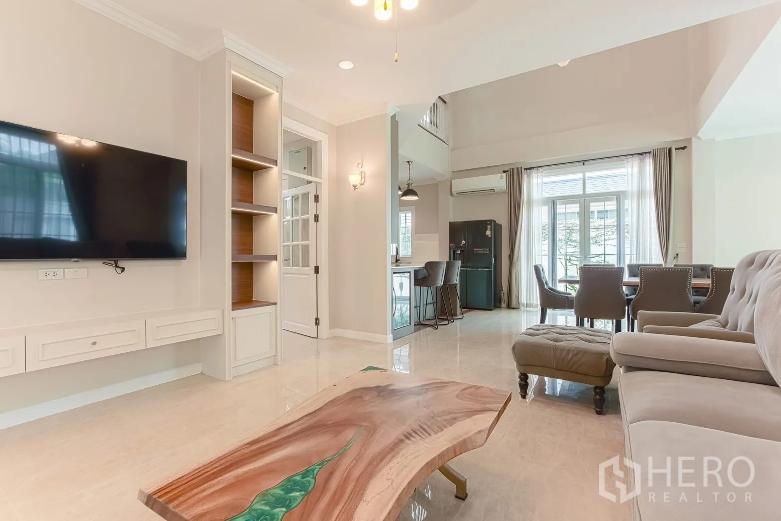 บ้านเดี่ยว for rent in Bang Na, Bangkok - ผนังทีวีและโต๊ะกลางมองไปยังโซนทานอาหารและครัว