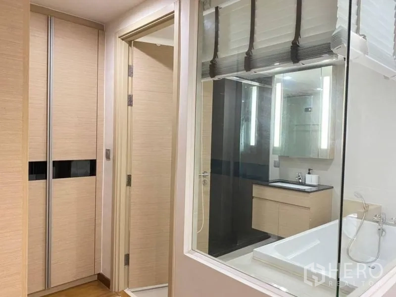 公寓 出租在Watthana, Bangkok - 走廊带嵌入式衣柜，通过玻璃可见配有浴缸的现代浴室