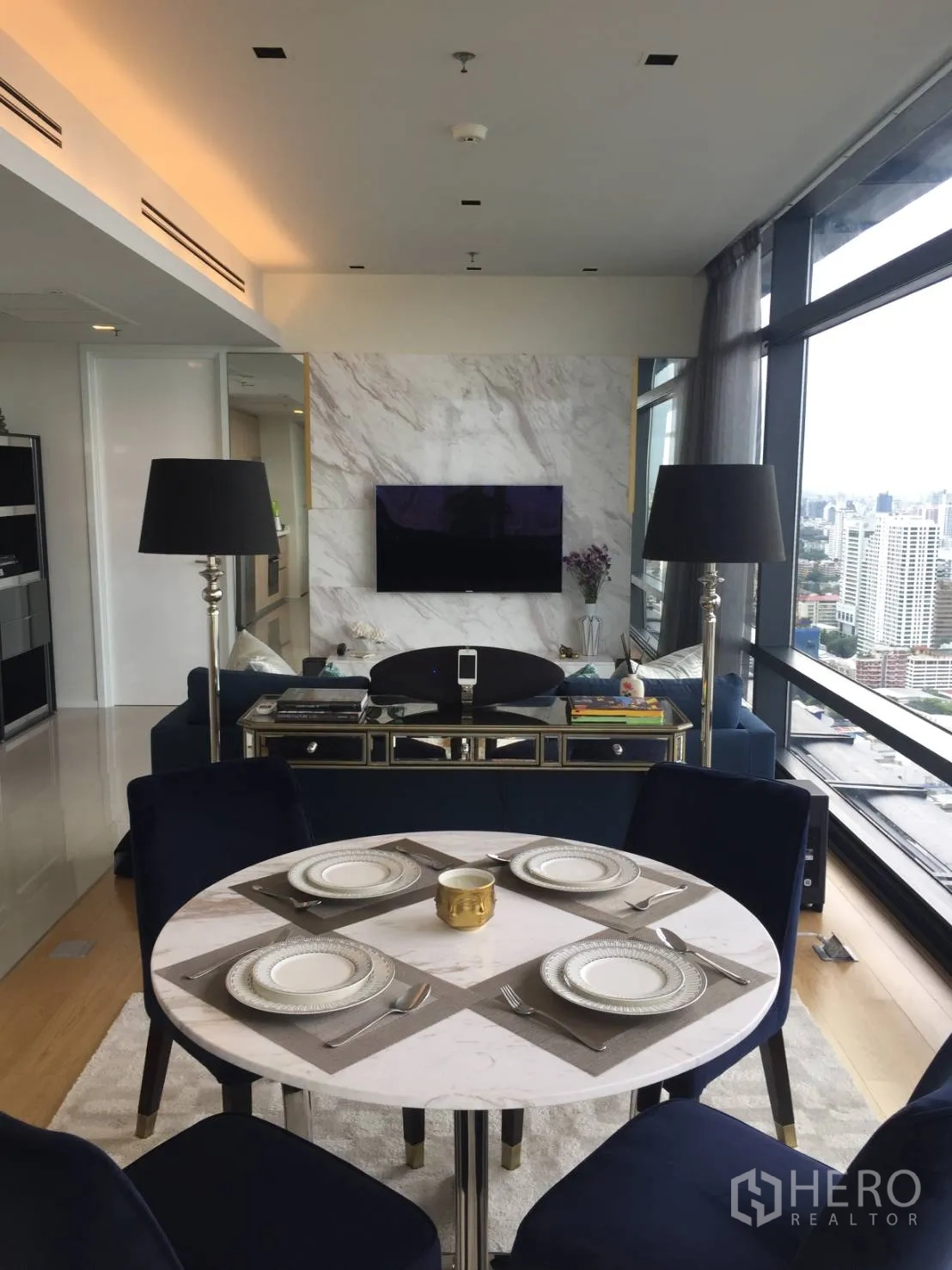 公寓 出租或出售在Ratchathewi, Bangkok - 用餐区朝向大理石电视墙，整面玻璃享城市景观。
