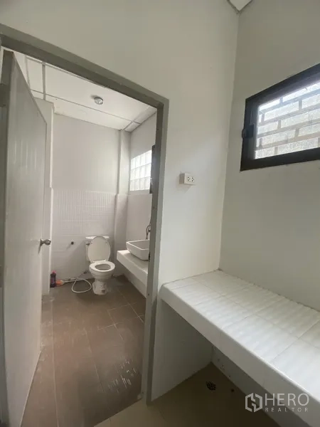 Townhouse for rent in Suan Luang, Bangkok - Utility corner beside a bathroom with countertop, sink and ventilation window.