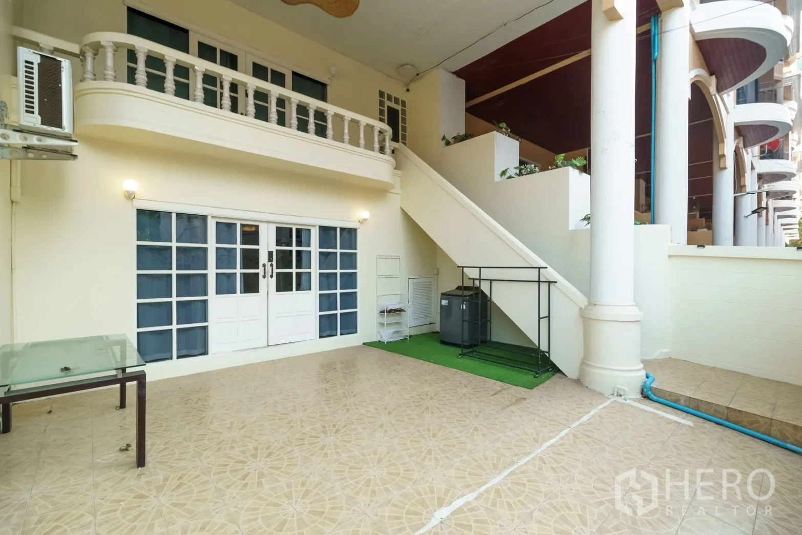 ทาวน์เฮาส์ for rent in Watthana, Bangkok - ลานหน้าบ้านชั้นล่างพร้อมประตูกระจกบานคู่และบันไดภายนอกใต้ซุ้มเสา