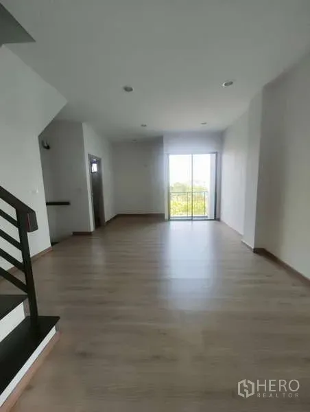 带办公室的家 出租在Bueng Kum, Bangkok - 楼上房间，木地板、楼梯旁筒灯照明，推拉玻璃门连接阳台。