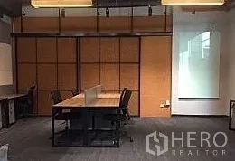 办公空间 出租在Khlong Toei, Bangkok - 现代办公室长条工位，暖色墙面与吊灯，位于空堤区。