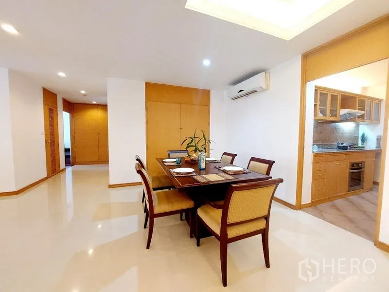 Apartment for rent - Dining area beside separate kitchen with wood cabinetry, air conditioner and glossy tile floors.