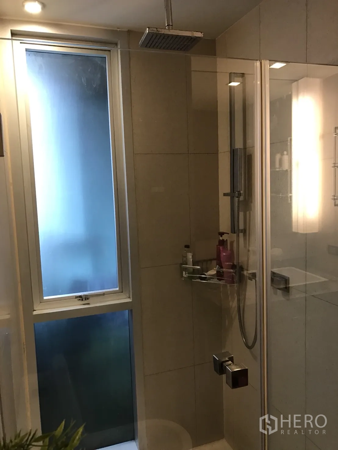 Condominium for rent or sale in Bang Rak, Bangkok - Modern bathroom with a glass shower enclosure, rainfall showerhead, and frosted window for natural light.