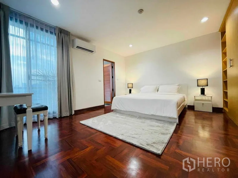 Condominium for rent - Bedroom with king bed, balcony access, and wood floors.