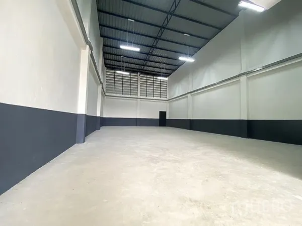 Warehouse for rent in Mueang Pathum Thani, Pathum Thani - Spacious high-ceiling warehouse bay with concrete floor, ventilation panels and LED lights.