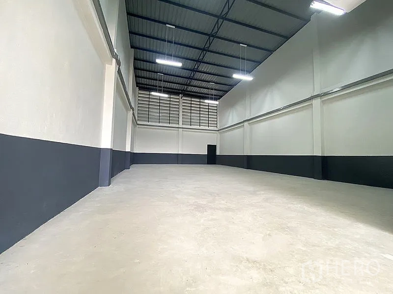 Warehouse for rent in Mueang Pathum Thani, Pathum Thani - Spacious high-ceiling warehouse bay with concrete floor, ventilation panels and LED lights.
