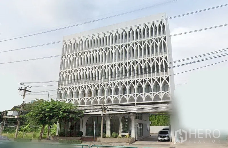 零售空间 出租在Huai Khwang, Bangkok - 曼谷主干道旁多层零售建筑，拱形格栅外立面，一层大面积玻璃门面与下客区，能见度高。