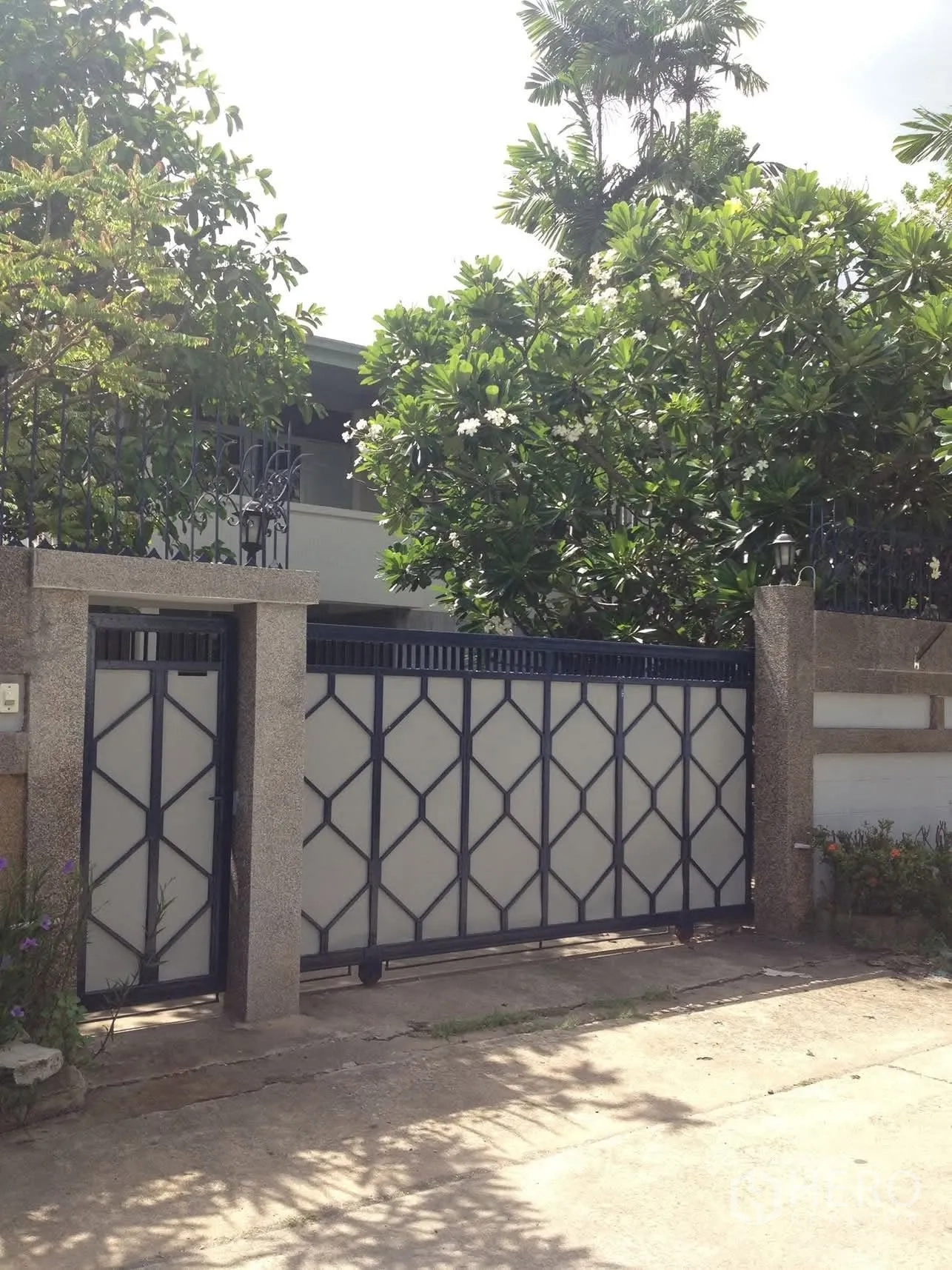 独栋房屋 for rent in Watthana, Bangkok - 安全前门与围墙，周边为热带植物。