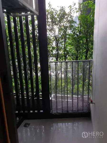 คอนโด ขายในWatthana, Bangkok - ระเบียงคอนโดขนาดกะทัดรัด มีซี่บังตา พื้นกระเบื้อง และวิวต้นไม้เขียวขจี