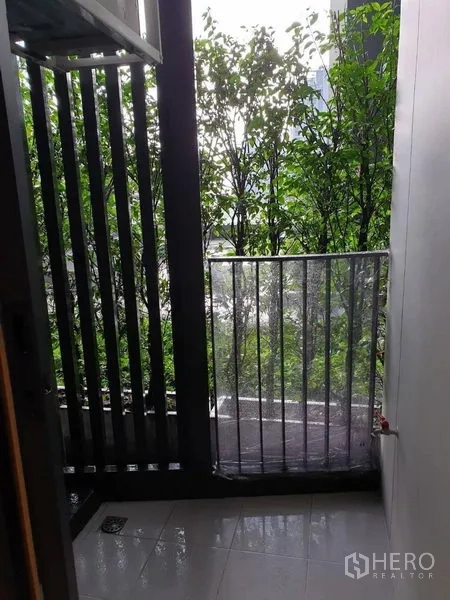 คอนโด ขายในWatthana, Bangkok - ระเบียงคอนโดขนาดกะทัดรัด มีซี่บังตา พื้นกระเบื้อง และวิวต้นไม้เขียวขจี