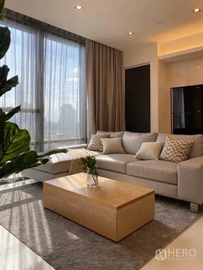 คอนโด ให้เช่าในSathon, Bangkok - มุมห้องนั่งเล่นอีกด้าน โซฟา โต๊ะกลางไม้ และหน้าต่างสูง