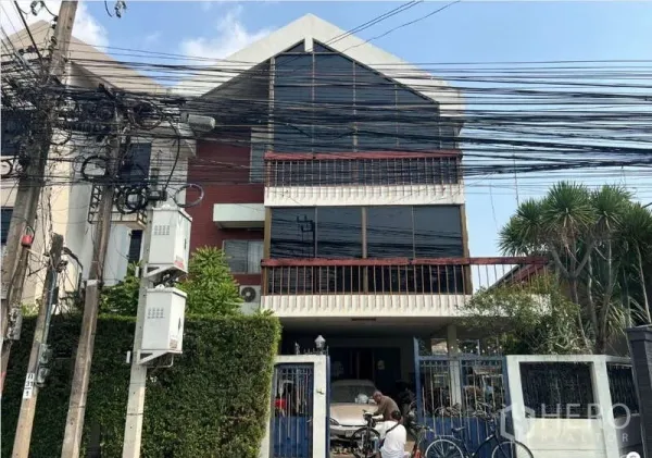 独立式住宅 出售在Suan Luang, Bangkok - 独栋别墅正立面，宽阔窗墙与阳台，设有蓝色入户大门。