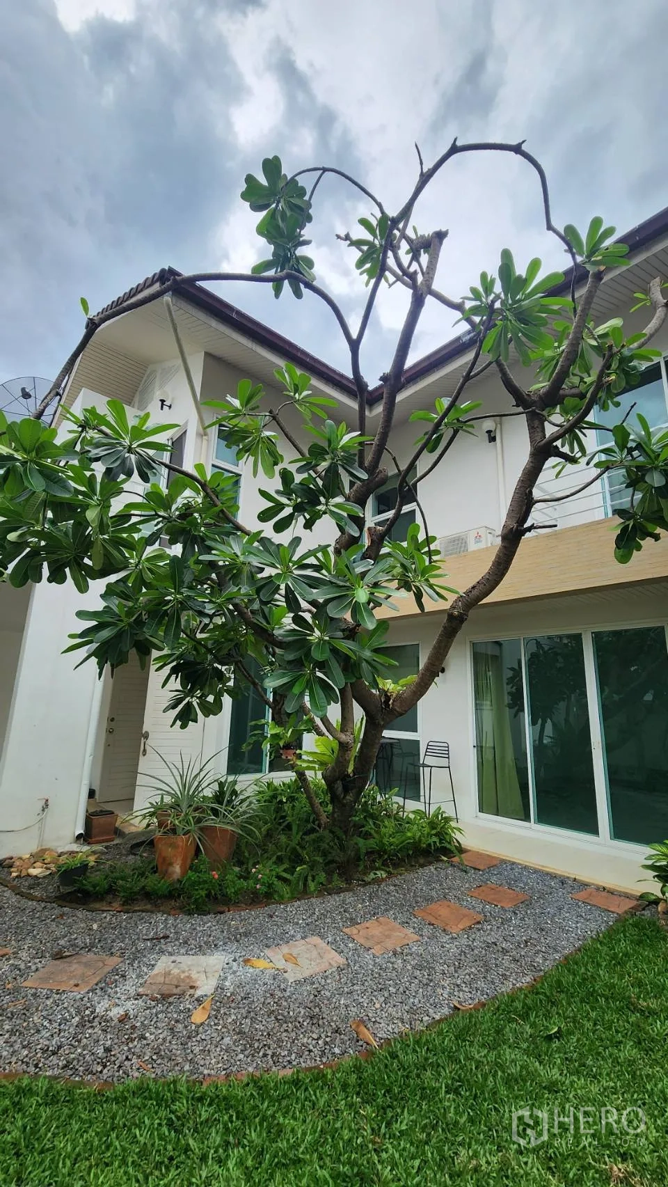 Detached House for rent in Watthana, Bangkok - Two-storey house exterior with balcony and mature tree in the front garden.