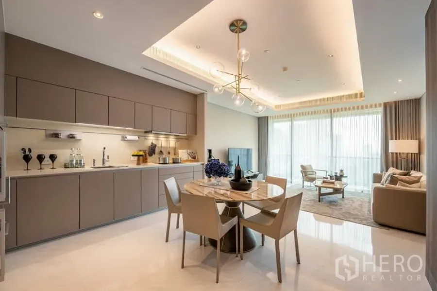公寓 出租或出售在Pathum Wan, Bangkok - 当代风格厨房与整墙柜体，旁接餐桌与明亮客厅