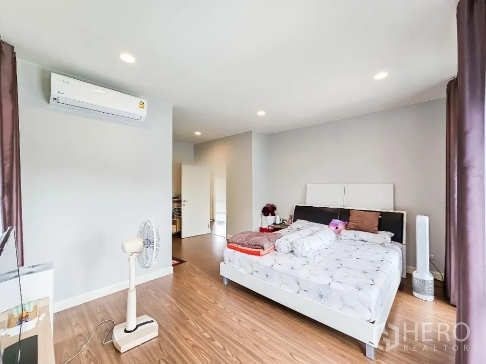 Detached House for sale in Lam Luk Ka, Pathum Thani - Master bedroom angle showing air-conditioner and double bed.