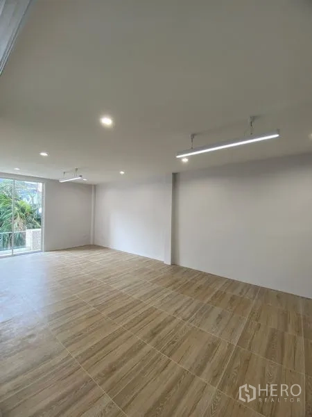 带办公室的家 出租或出售在Suan Luang, Bangkok - 明亮房间，木纹地面、LED线性灯，望向阳台。