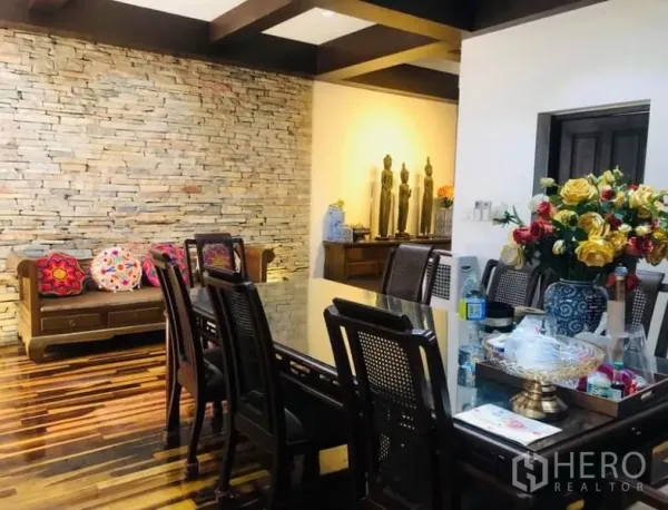 คอนโด ให้เช่าในPathum Wan, Bangkok - พื้นที่รับประทานอาหาร โต๊ะกระจก เก้าอี้หวายพนักพิง และผนังหินกาบตกแต่ง