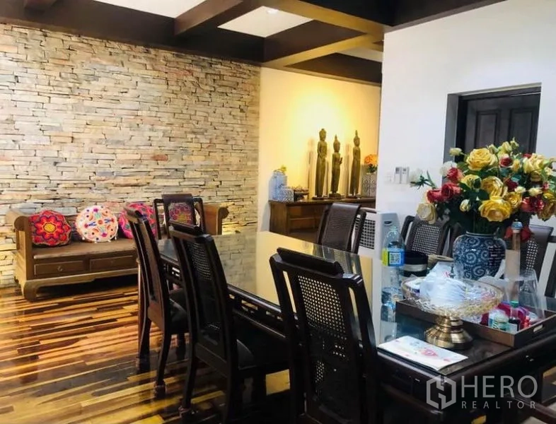 คอนโด ให้เช่าในPathum Wan, Bangkok - พื้นที่รับประทานอาหาร โต๊ะกระจก เก้าอี้หวายพนักพิง และผนังหินกาบตกแต่ง