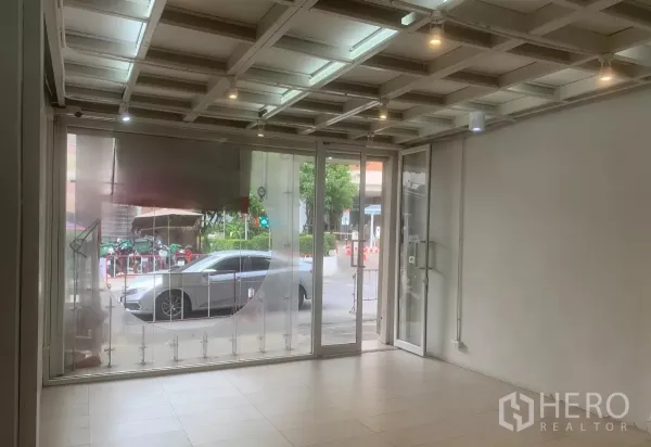 Retail Space for rent in Yan Nawa, Bangkok - Bright retail space with full-height glass storefront facing the street, tiled floor and spotlights.