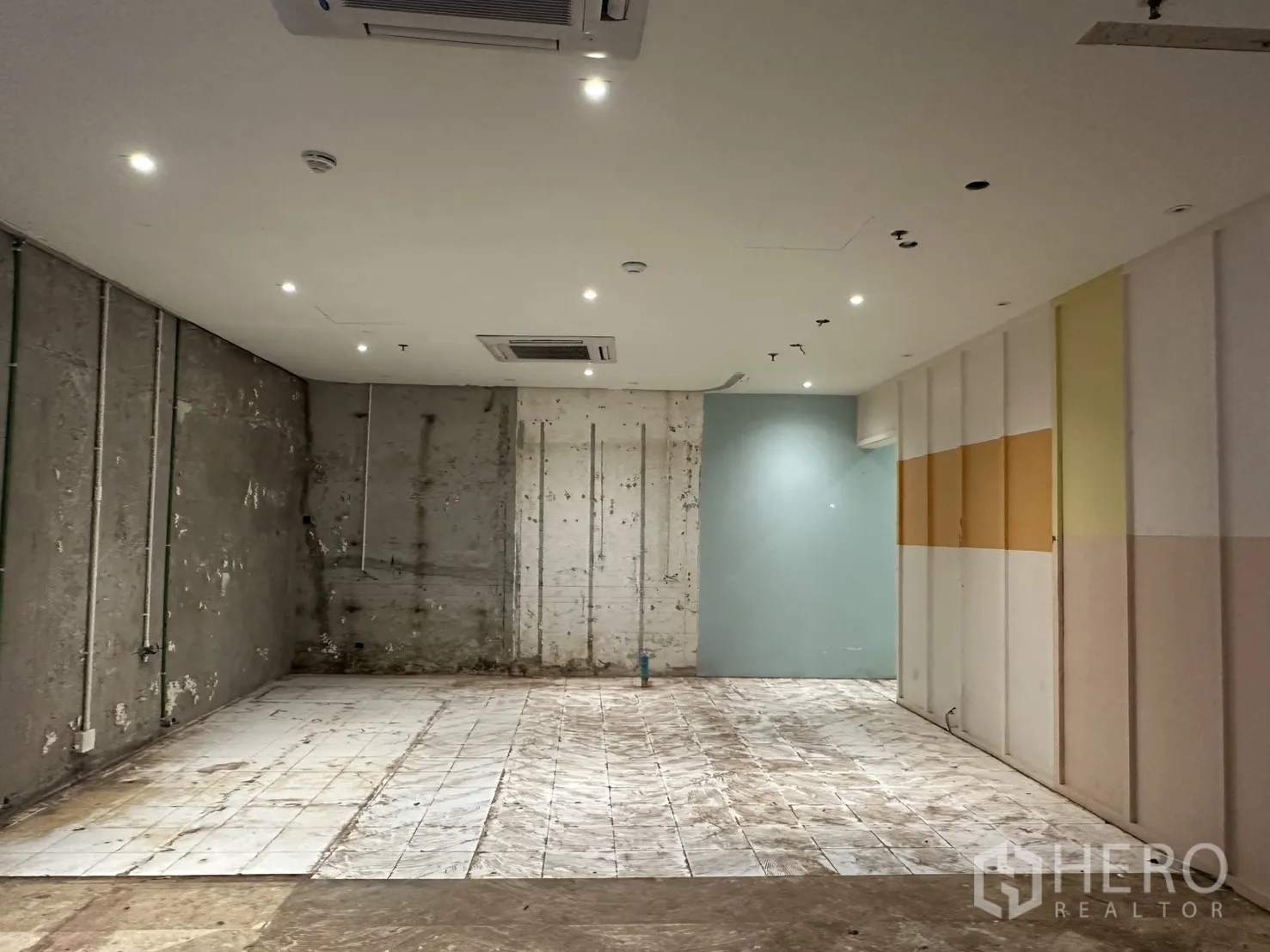 零售空间 for rent in Watthana, Bangkok - 开阔零售毛坯空间，天花嵌灯与嵌入空调，未完成墙面及部分瓷砖地面。